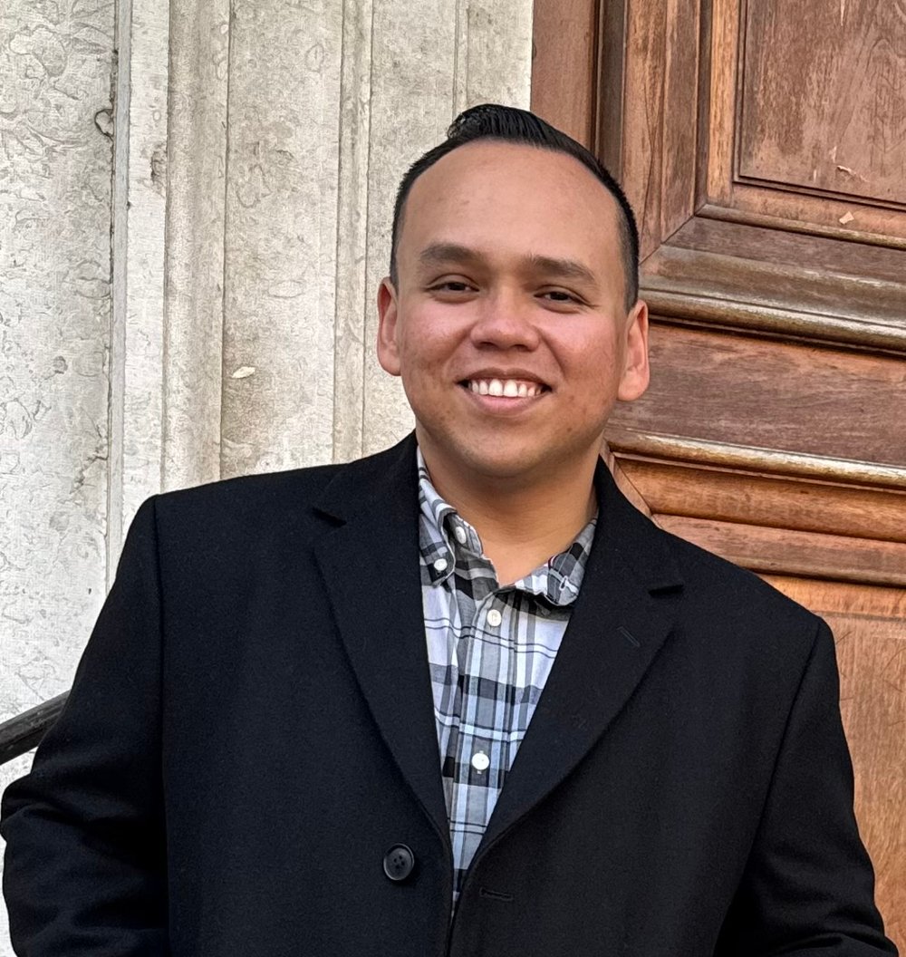 Shaun Niyo-Ramdas, founder of Homeless Services Learning Lab, smiling in a dark blazer.